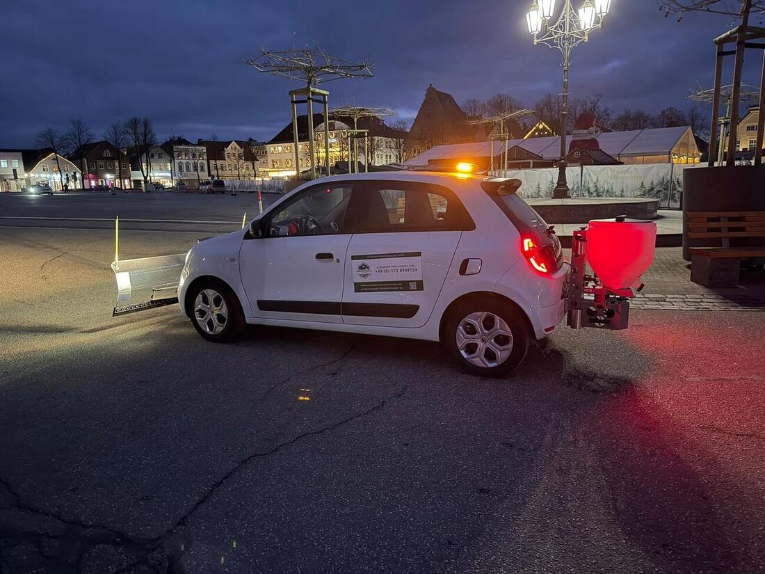 Winterdienstfahrzeug mit Streuaufsatz im nächtlichen Einsatz